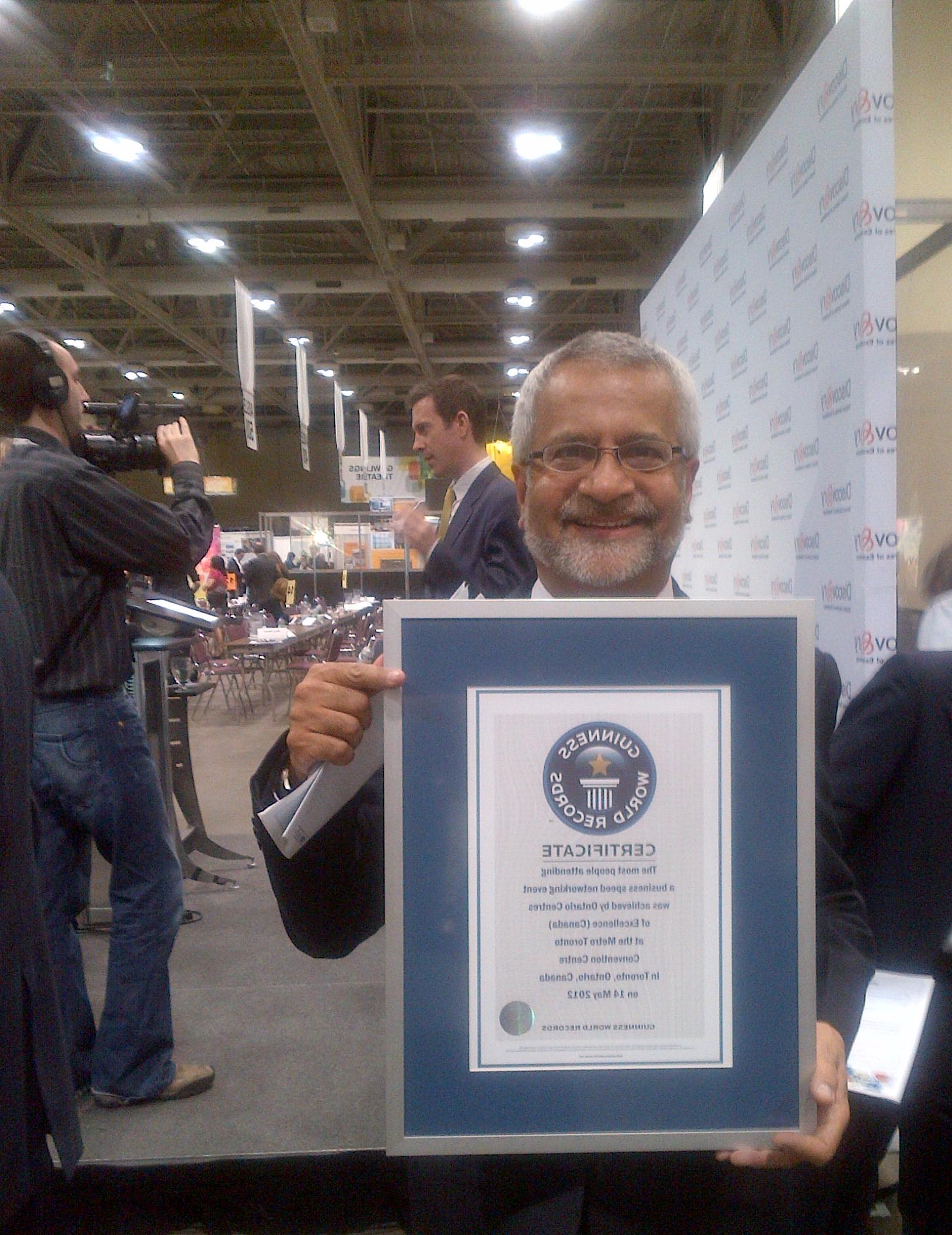 This is an image of Professor Nathwani holding the Guiness World Record Certificate at the Ontario Centres of Excellence Discover 12 Conference